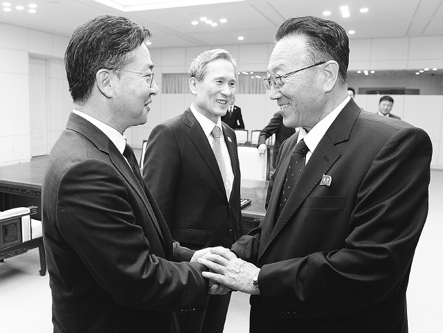 29일 교통사고로 사망했다고 북한이 밝힌 김양건 북한 통일전선부장（오른쪽)이 지난 8월25일 새벽 판문점 평화의 집에서 남북 고위급 접촉 공동합의문에 합의한 뒤 홍용표 통일부 장관과 악수하고 있다. <한겨레> 자료사진