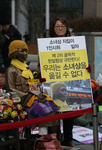 31일 오전 서울 종로구 중학동 주한일본대사관 앞 ‘평화의 소녀상’ 옆에서 류은숙씨가 소녀상 철거를 반대하는 내용을 적은 손팻말을 들고 1인시위를 하고 있다. 신소영 기자 viator@hani.co.kr