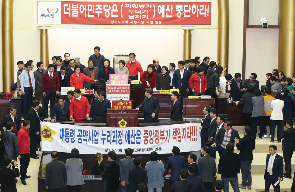 지난 31일 오후 경기도 수원시 경기도의회에서 본회의장에서 누리과정 예산을 포함한 내년도 예산안 의결에 반대해 의장석을 점거한 새누리당 의원들과 의장석 진입을 시도하던 더불어민주당 의원들이 몸싸움을 하고 있다. 연합뉴스