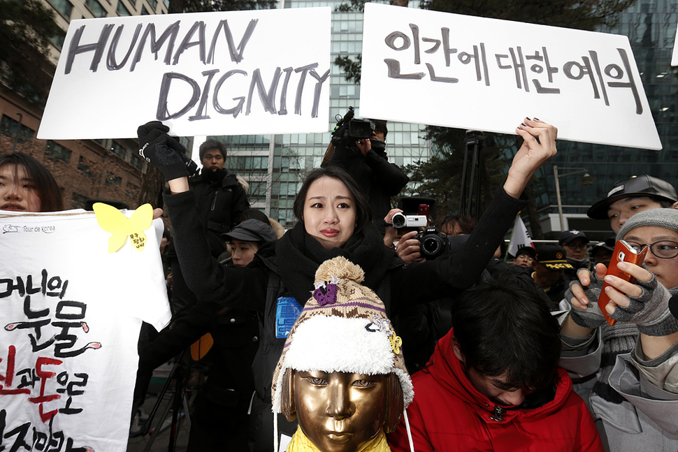 6일 오후 서울 종로구 중학동 일본대사관 앞에서 어버이연합이 아베 총리와 아베 총리의 외할아버지 기시 노부스케의 가면을 쓰고 소녀상에 절을 하자 예술가 홍승희씨가 눈물을 흘리며 항의의 내용이 담긴 손팻말을 들고 있다. 김명진 기자 littleprince@hani.co.kr