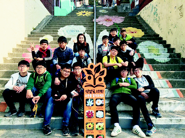 지난해 10월 부산 영남중학교 독서동아리 ‘영마루 싱크 카페’ 회원들과 이해교 지도교사가 산복도로를 둘러보던 도중 닥나무가 많이 나는 닥밭골 행복마을 계단에서 잠시 쉬고 있다. 이해교 교사 제공