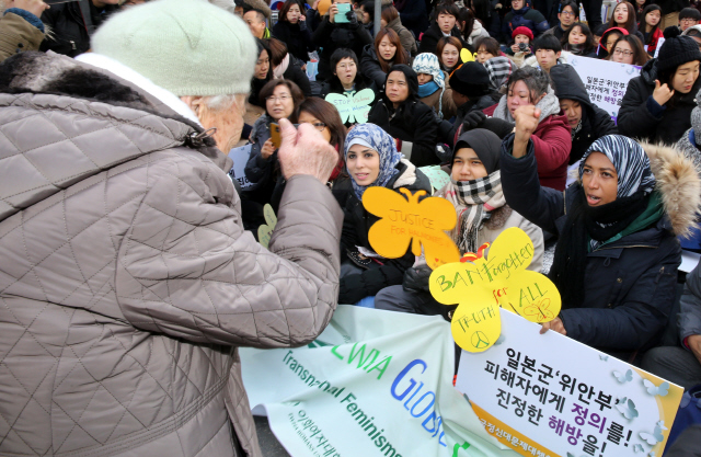 13일 낮 서울 중학동 주한일본대사관 앞에서 한국정신대문제대책협의회 주최로 열린 제1213차 일본군 ‘위안부’ 문제 해결을 위한 정기 수요시위에서, 이옥선 할머니(왼쪽 등 보이는 이)가 이날 행사에 참가한 아시아·아프리카 지역 여성 활동가들을 바라보며 파이팅을 외치고 있다. 강재훈 선임기자 khan@hani.co.kr