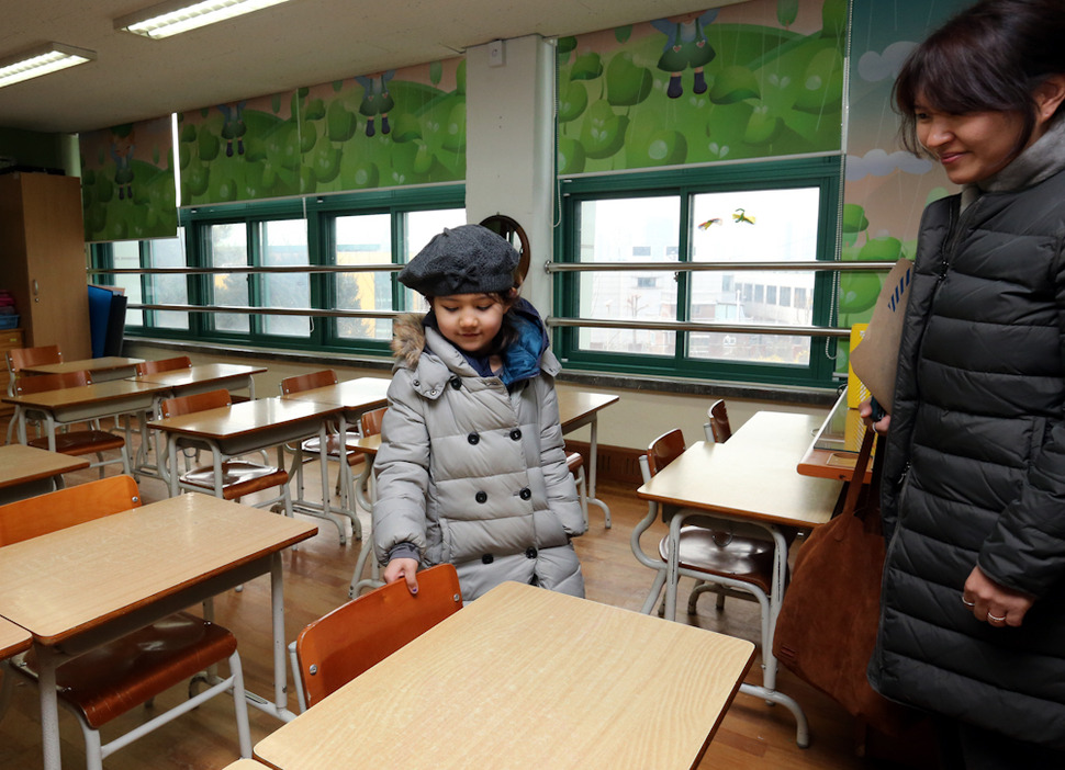 13일 오후 서울 용산구 이태원초교에서 입학등록을 마친 어린이가 1학년 교실에서 의자에 앉아 보고 있다. 김태형 기자 xogud555@hani.co.kr