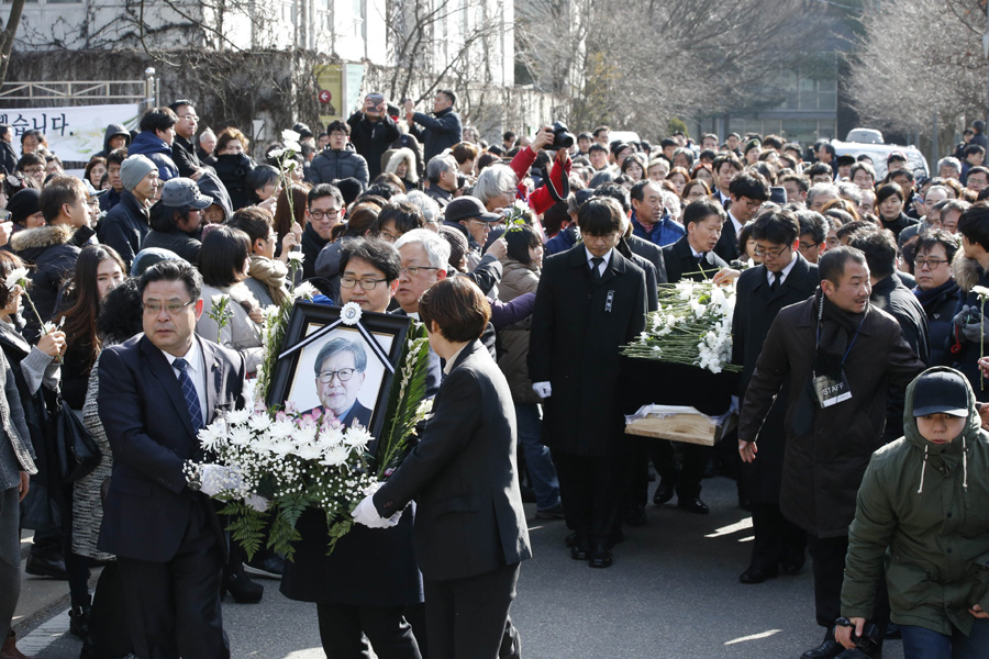 신영복 성공회대 석좌교수의 영결식이 열린 18일 오전 서울 구로구 성공회대에서 추모객들이 고인의 영정을 앞세운 운구행렬이 지나가자 손에 들고 있던 국화꽃을 놓으며 마지막 가는 길을 배웅하고 있다.  김봉규 선임기자 bong9@hani.co.kr