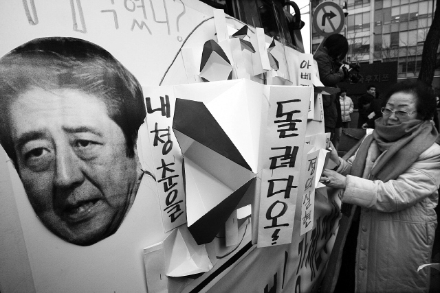 아베 신조 일본 총리는 “일본군 ‘위안부’ 강제동원의 증거가 없다”고 종종 말해왔다. 2007년 3월 발언 때 서울 종로구 주한일본대사관 앞에서, 17살에 끌려간 이용수 할머니가 아베 총리의 사과를 요구하는 내용을 담은 팻말을 붙이고 있다. 박종식 기자 anaki@hani.co.kr