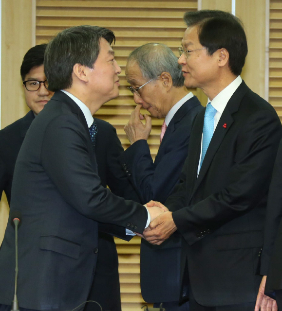 안철수 국민의당 인재영입위원장(왼쪽)과 천정배 국민회의 창당준비위원장이 25일 오전 국회 의원회관에서 통합선언을 한 뒤 악수하고 있다. 뒤편 가운데는 윤여준 국민의당 공동창당준비위원장. 
 이정우 선임기자 woo@hani.co.kr