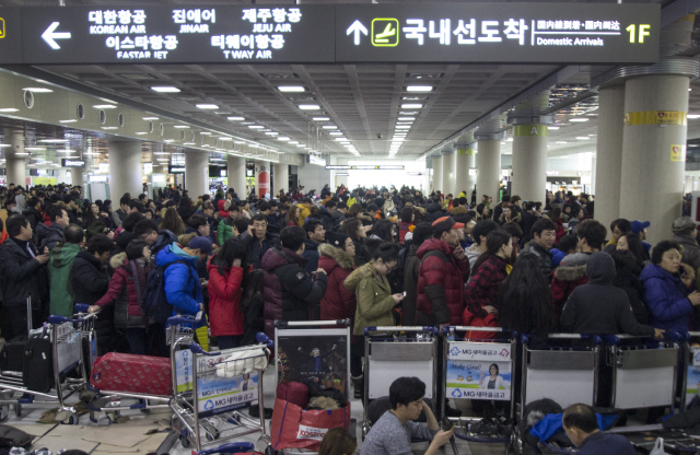 제주공항 안과 밖 폭설과 강풍으로 인해 발이 묶였던 관광객들이 25일 오후 제주시 용담동 제주국제공항에서 발권을 하기 위해 길게 줄 서 있다. 제주/김성광 기자 flysg2@hani.co.kr