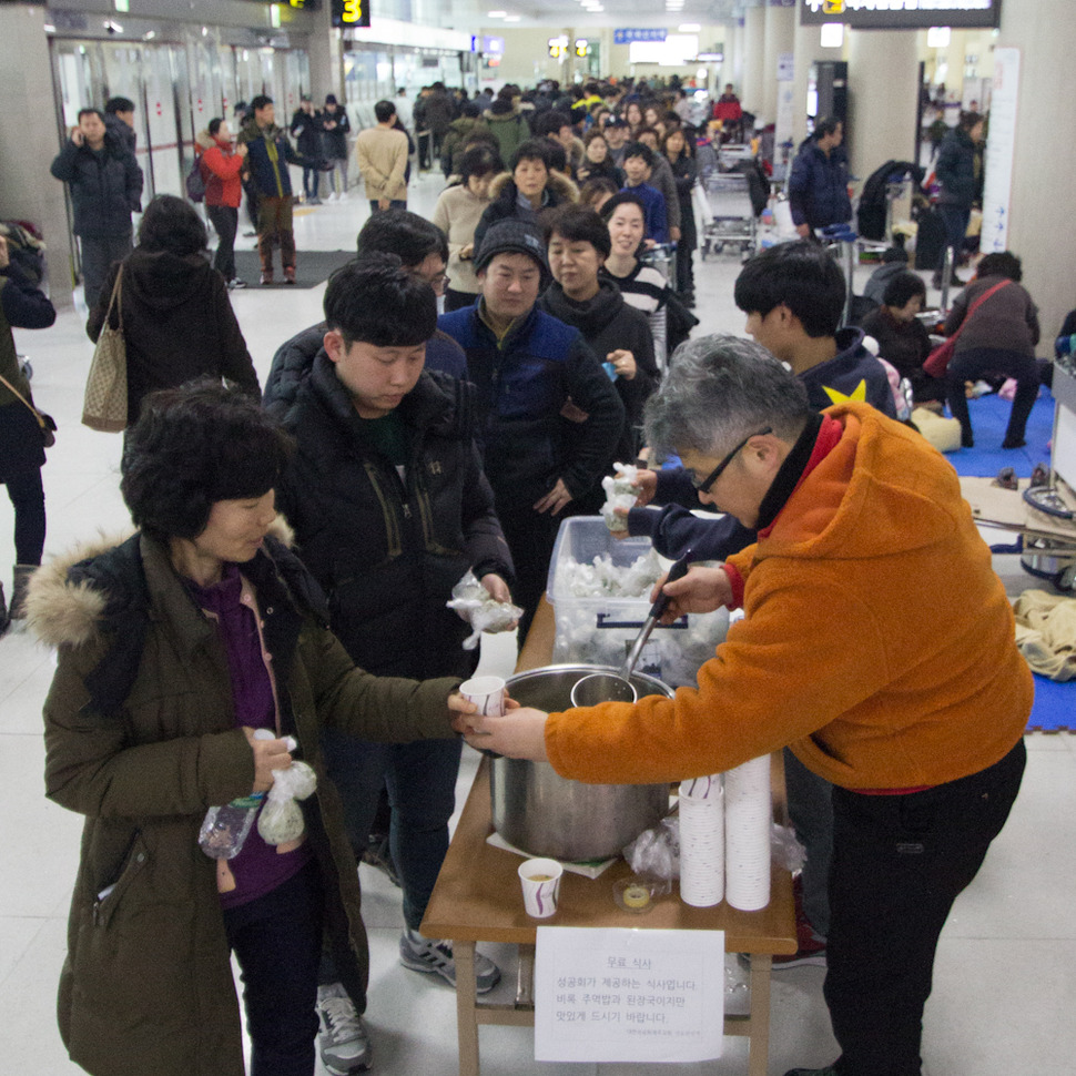 25일 오전 4일째 모든 운항이 중단된 제주공항에서 체류중인 관광객들이 대한성공회 제주교회가 준비한 주먹밥과 된장국을 받고 있다. 제주/김성광 기자 flysg2@hani.co.kr