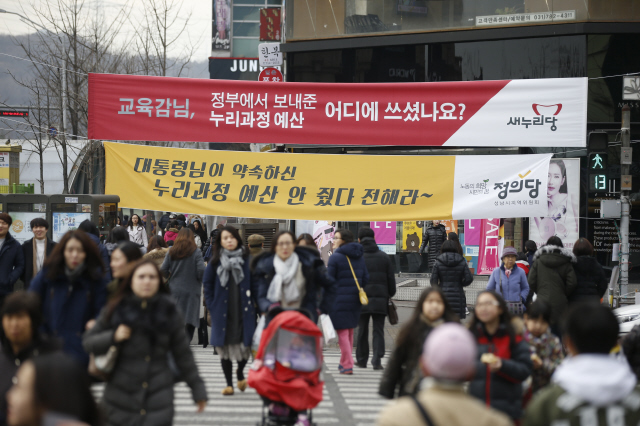 누리과정(만 3~5살 무상교육) 예산 문제와 관련해 새누리당이 교육청을 비난하며 내건 펼침막(위쪽)과 정부 여당을 비판하는 내용의 정의당 펼침막이 28일 오후 경기도 성남시 분당구 미금역 네거리에 나란히 걸려 있다.  성남/이정아 기자 leej@hani.co.kr