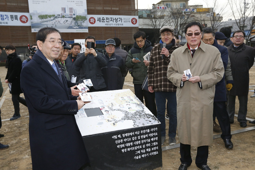 박원순 서울시장(왼쪽)이  28일 오전 서울 종로구 장사동 세운상가 가동 앞 초록띠공원에서 얼굴이 담긴 타일을 붙이는 상징의식을 하고 있다. 김봉규 선임기자 bong9@hani.co.kr