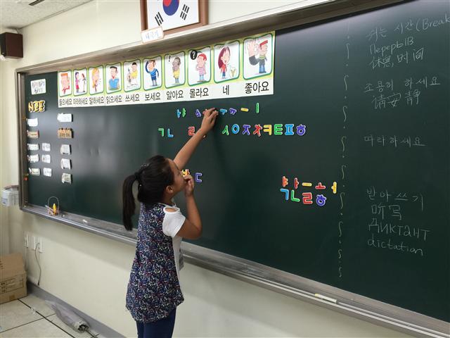 2. 한누리학교 학생들이 한글을 배우고 있다. 칠판에는 수업에 필요한 한국어가 그림설명과 함께 붙어 있다.  한누리학교 제공