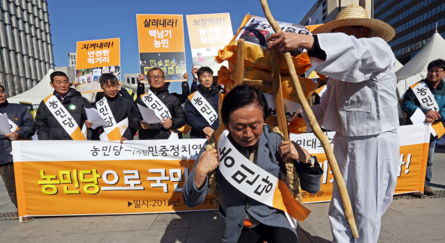 농민당 건설을 위한 농민 대표자 선언 기자회견이 16일 오전 서울 광화문광장에서 열려 이광석 민중정치연합 농민추진위원회 대표가 한 농민으로부터 자유무역협정(FTA) 추진 등으로 인한 쌀 시장 완전개방 등 농민의 고민이 담긴 지게를 넘겨받는 상징의식을 하고 있다. 농민당은 흙수저 청년, 비정규직 노동자 등과 함께 소외된 99%의 이익을 대변하는 ‘민중정치연합’(가칭)을 만들어 20대 총선에 참여한다는 계획이다.    이정용 선임기자 lee312@hani.co.kr