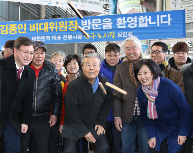  김종인 더불어민주당 대표(가운데)가 21일 오후 서울 구로구 남구로시장을 방문해 이 지역에 지역구를 둔 박영선 의원(앞줄 맨 오른쪽), 시장 상인들과 함께 윷을 놀고 있다.  이정우 선임기자 woo@hani.co.kr