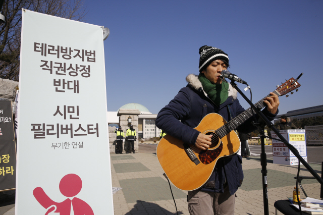 24일 오전 국회 정문 앞에서는 1인조 인디밴드 ‘하늘소년’이 ‘시민 필리버스터’에 참여해 테러방지법 직권상정에 반대하는 노래를 부르고 있다. 김봉규 선임기자