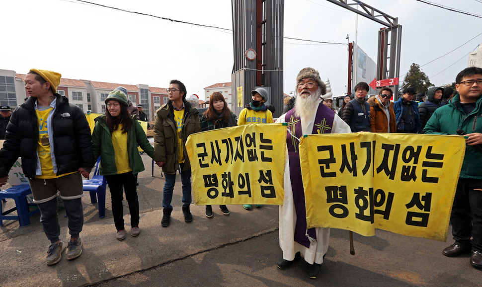 제주 서귀포 강정해군기지 준공식이 열린 26일 해군기지 공사장 입구에서 강정마을 주민들과 시민단체 회원들이 인간띠잇기를 하고 있다. 서귀포/ 이정용 선임기자 lee312@hani.co.kr