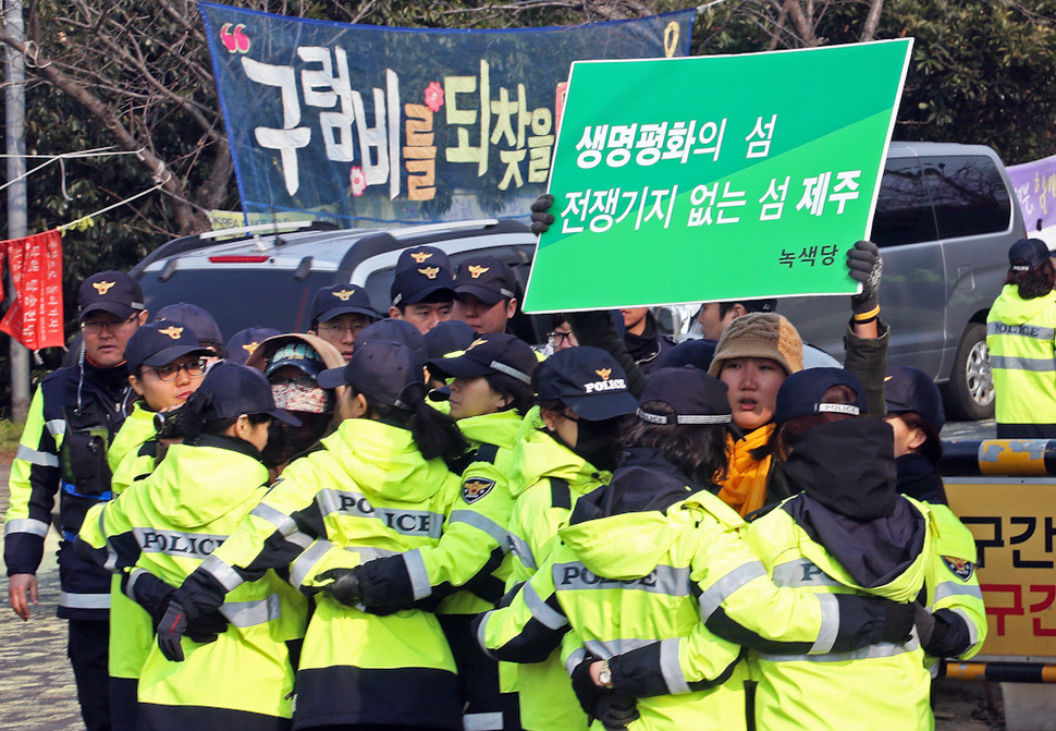 제주 서귀포 강정해군기지 준공식이 열린 26일 해군기지 공사장 입구에서 강정마을 주민들과 시민단체 회원들이 손팻말을 들고 시위를 벌이고 있다. 서귀포/ 이정용 선임기자 lee312@hani.co.kr