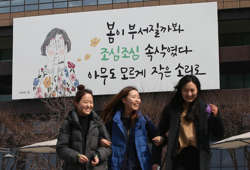 2일 오후 서울 광화문 광장 교보빌딩에 봄을 알리는 내용의 ‘봄이 부서질까봐 조심조심 속삭였다. 아무도 모르게 작은 소리로..’로 바뀐 현판 앞으로 시민들이 지나가고 있다. 이번 문구는 최하림 시인의 ‘봄‘에서 발췌한 것이다. 신소영 기자 viator@hani.co.kr