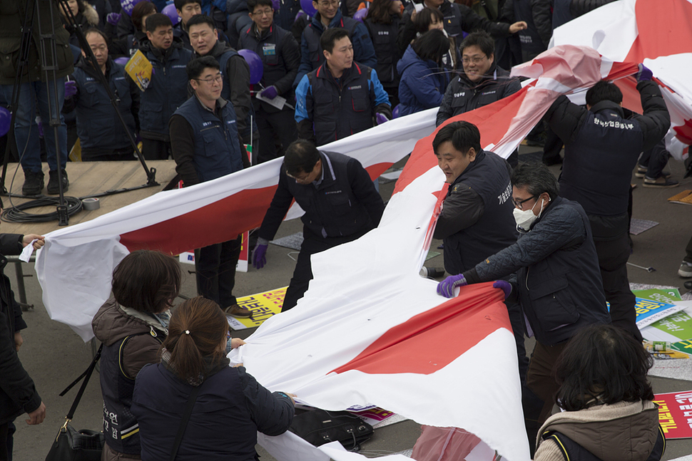 제108주년 세계 여성의 날인 8일 오후 서울 중구 서울역광장에서 한국노총 조합원들이 전국 여성 노동자대회를 열어 여성들의 노동환경을 악화시킬 수 있는 정부의 노동법 개악 강행을 저지하고 쉬운해고 및 취업규칙 일방변경 지침을 규탄하는 의미로 대형 필침막을 찢고 있다. 김성광 기자 flysg2@hani.co.kr