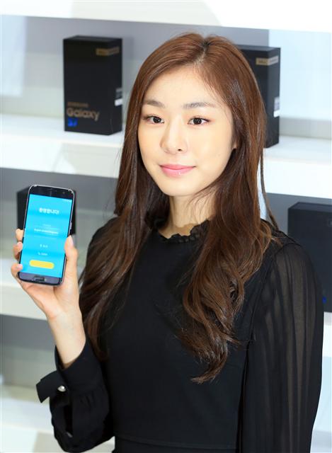 전 피겨스케이팅 선수 김연아가 11일 오전 서울 종로구 관철동 에스케이텔레콤 티(T)월드카페 종각점에서 열린 ‘갤럭시S7’ 개통 행사에서 1호 개통 고객에게 전달할 제품을 들어 보이고 있다. 연합뉴스