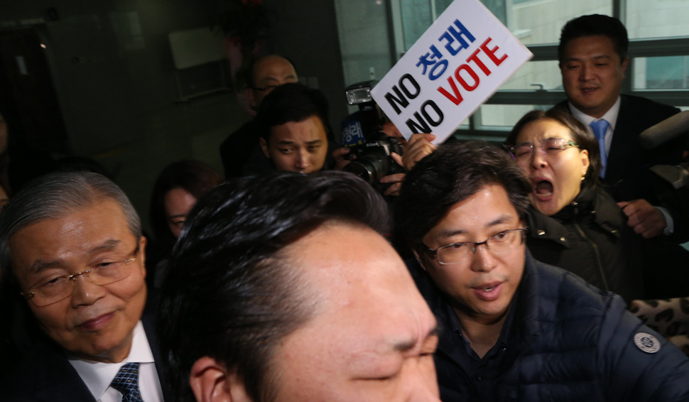 김종인 더불어민주당 비상대책위원회 대표가 13일 오후 국회 의원회관에서 더불어경제콘서트에 참석했다가 행사장을 나서자 공천에서 탈락한 정청래 의원 지지자들이 공천 재심을 요구하며 김 대표를 향해 팻말을 흔들고 있다. 이정우 선임기자 woo@hani.co.kr