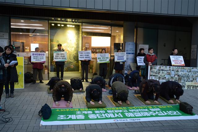 조계종 종립 고등학교인 서울 동대부고에서 근무하다 전보 발령을 받은 교사들(앞줄 왼쪽 둘째와 셋째)이 징계성 인사가 부당하다며 동료 교사들과 조계사 맞은편 길가에서 108배를 하고 있다.  김성보 교사 제공