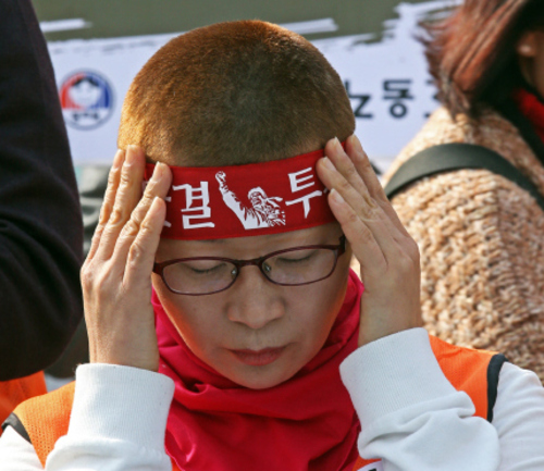 전국교직원노동조합(전교조)이 14일 오후 서울 종로구 정부서울청사 앞에서 연 ‘전교조 본부 복귀거부 전임자 삭발투쟁’ 기자회견에서 삭발을 한 전교조 회원이 머리띠를 두르고 있다. 이정용 선임기자 lee312@hani.co.kr