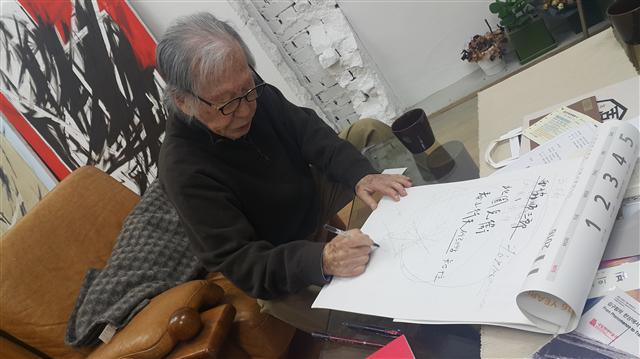 김병기 화백이 유학 시절 어울렸던 일본 예술인들의 이름과 행적들을 종이에 일일이 적어내려가며 설명하고 있다. 사진 노형석 기자