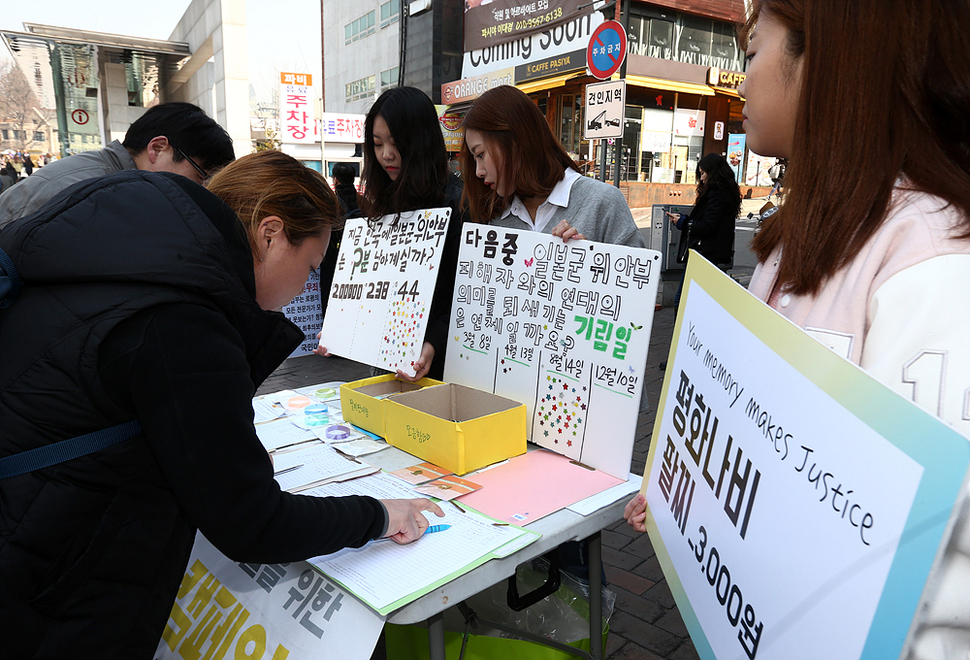 16일 오후 서울 서대문구 이화여자대학교 정문 앞에서 열린 ‘일본군 위안부 문제 해결을 위한 평화나비 캠페인’에서 평화나비네트워크 이화나비 소속 대학생들이 시민들에게 서명을 받고 있다. 연합뉴스