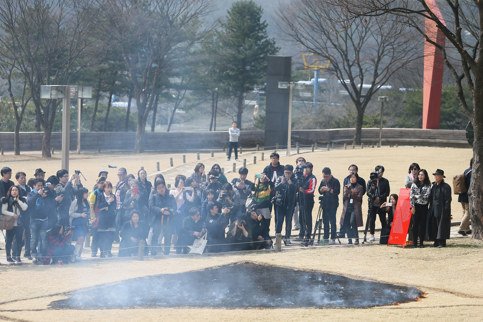 김구림 작가가 18일 오후 경기 과천시 막계동 국립현대미술관 과천관 야외 조각공원에서 ‘현상에서 흔적으로 - 불과 잔디에 의한 이벤트‘(1970) 퍼포먼스를 재연하고 있다. 2016.3.18 연합뉴스