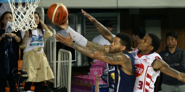 케이비엘(KBL)의 1m93 이하 단신 외국인 보유 규정에 따라 뛰게 된 케이씨씨의 안드레 에밋(왼쪽)과 오리온의 조 잭슨은 농구팬들에게 개인기 농구의 진기명기를 선물했다. 사진은 27일 챔피언결정 5차전에서 맞붙은 두 선수.   전주/연합뉴스
