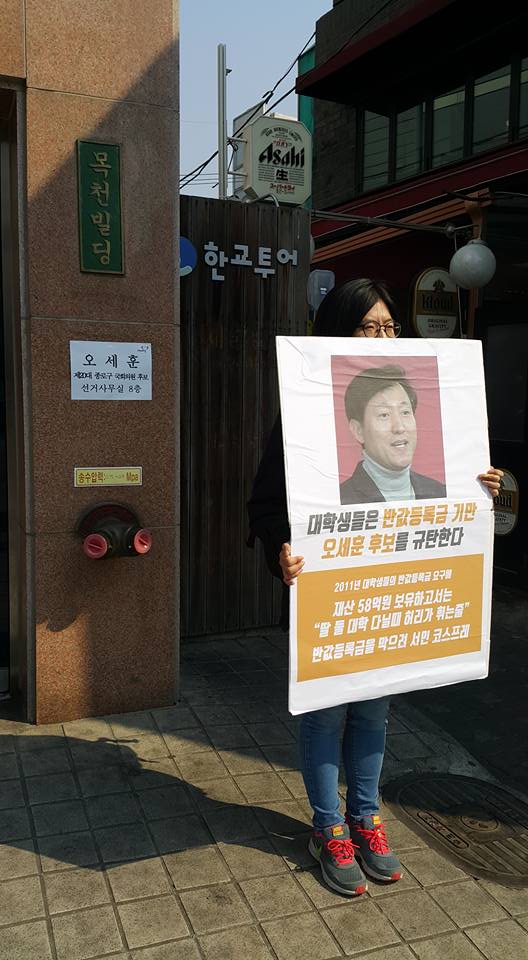 21세기한국대학생연합 등 대학생 단체들로 구성된 ‘4·13총선 대학생참여 네트워크 무브(Move)’ 대학생이 3월28일 서울 종로구 오세훈 새누리당 후보 사무실 앞에서 반값등록금 기만 오세훈 후보 규탄 1인 시위를 하고 있다. 사진 한국대학생연합 제공