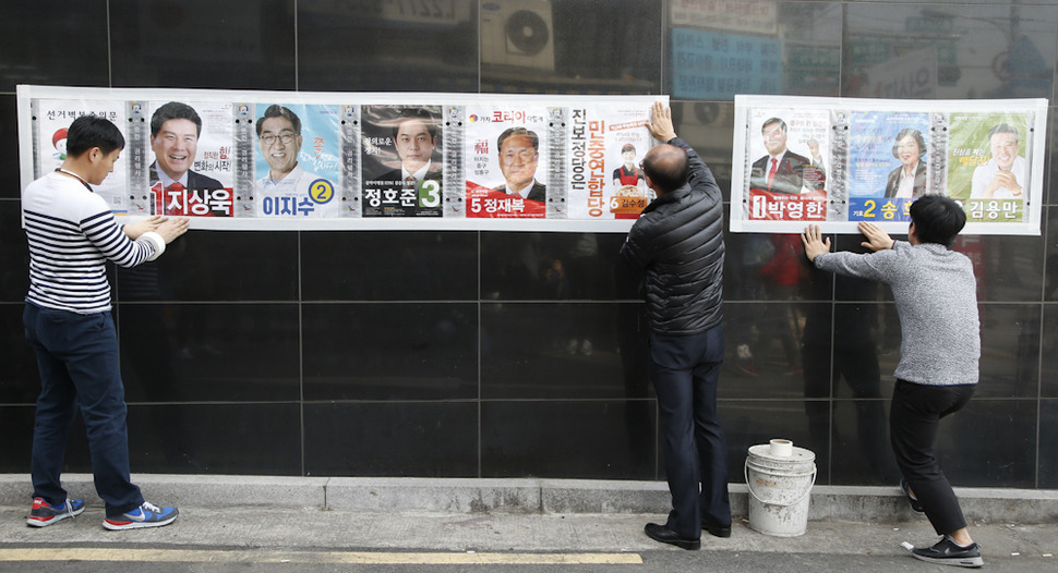 제20대 국회의원 선거 공식 선거운동이 시작된 31일 오전 서울 중구 을지로4가 인도에서 중구청 직원들이 국회의원과 구의회의원 후보자들의 선거 벽보를 게시하고 있다. 이정아 기자 leej@hani.co.kr