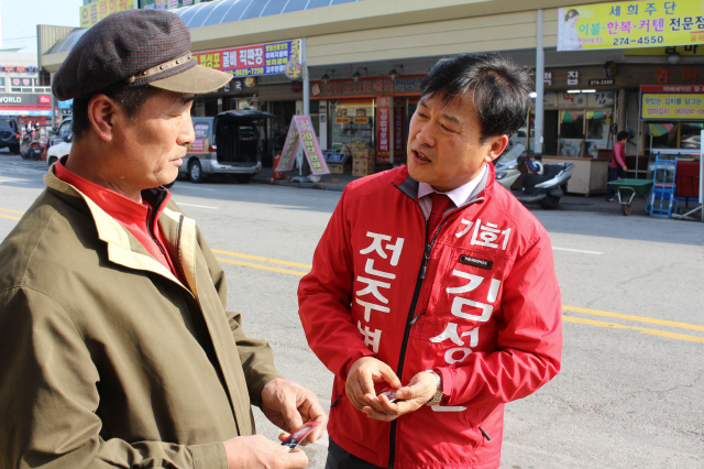지난 30일 전주 덕진구 인후동의 모래내시장에서 새누리당 김성진 후보가 시민과 대화를 나누고 있다. 사진 송경화 기자