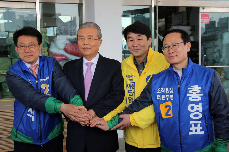 더불어민주당 김종인 비상대책위 대표가 3월30일 오후 인천 남구 노인인력센터를 방문한 뒤 인천 남구갑 허종식 후보(왼쪽), 더불어민주당과 정의당 단일후보인 남구을 김성진 후보(왼쪽 세번째), 인천 부평구을 홍영표 후보(오른쪽)와 손을 맞잡고 있다. 연합뉴스