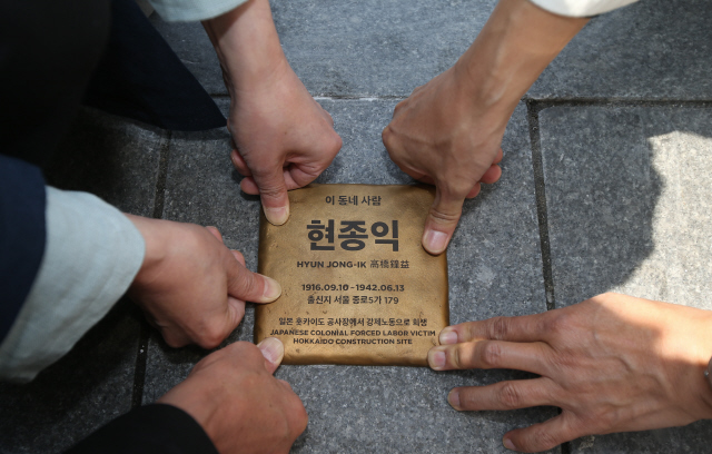 평화디딤돌과 동아시아시민네트워크 관계자들이 5일 낮 서울 지하철 종로5가역 5번 출구 근처 바닥에 일제강점기 강제징용 희생자인 현종익씨의 이름과 출신지 등을 새긴 ‘평화디딤돌’을 설치하고 있다. ‘평화디딤돌’은 강제징용 희생자들이 살았던 고향땅에 추모의 의미를 담아 설치하는 상징물이다. 지난해 추석에는 한국과 일본의 종교인·학자·학생 등이 18년 동안 발굴·수습한 희생자 유골 총 115구를 한국으로 운구해 서울시립묘지에 안치하고 ‘70년 만의 귀향’ 묘역을 조성했다.  신소영 기자 viator@hani.co.kr