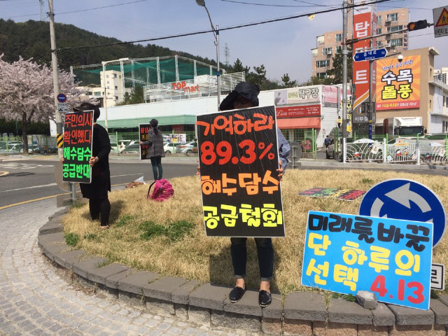 6일 오전 우미정(가운데)씨를 비롯한 주부 3명이 기장읍에 위치한 차량 회전구간에서 해수담수 공급 철회 등의 내용이 적힌 팻말을 들고 선전전을 하고 있는 모습. 사진 오승훈 기자