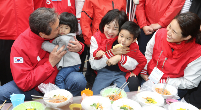 김무성 새누리당 대표(왼쪽)가 11일 오후 자신의 지역구인 부산 중구 광복로 먹자골목 노점에서 부인 최양옥 씨(오른쪽)와 장녀, 외손주들과 함께 어묵과 비빔당면을 먹고 있다.  부산/김경호 선임기자 jijae@hani.co.kr