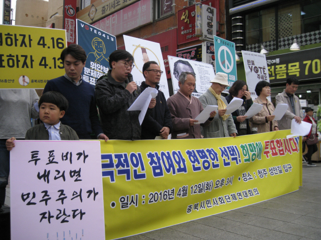 충북시민사회단체연대회의 회원 등이 12일 오후 청주 성안길에서 ‘투표비가 내리면 민주주의가 자란다’라고 쓴 손팻말을 들고 시민들에게 투표 참여를 권하고 있다.  오윤주 기자 sting@hani.co.kr