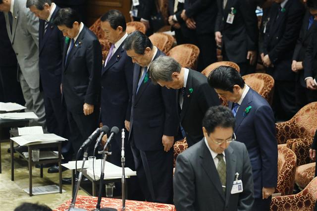 18일 일본 도쿄 국회 의사당에서 아베 신조(오른쪽) 일본 총리가 다른 의원들과 함께 구마모토 지진 희생자를 추모하는 묵념을 하고 있다.  도쿄/AFP 연합뉴스