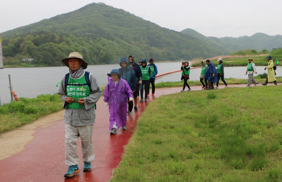 불교환경연대 ‘4대강 생명살림 100일 수행길’에 참가한 사람들이 지난달 27일 오전 가랑비가 내리는 가운데 금강 공주보 상류 강변을 지나고 있다. 맨 앞에 선 이가 불교환경연대 상임대표 법일 스님이다.