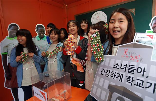 3일 오전 서울 중구 태평로 청계광장에서 월드비전 주최로 열린 ‘꽃들에게 희망을’ 행사에 참가한 학생들이 아프리카 아동들을 위해 만든 면 생리대를 들어 보이고 있다.  연합뉴스