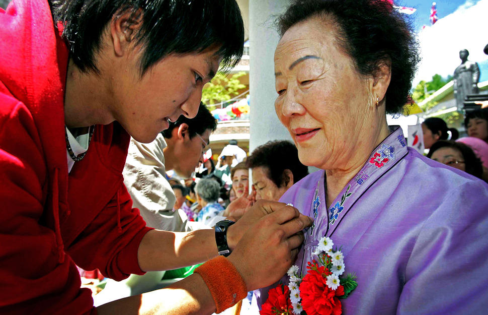 어버이날을 하루 앞둔 2006년 5월 7일 오후 ‘일본군 위안부 피해 할머니들을 위한 효도잔치’가 열린 경기 광주시 퇴촌면 ‘나눔의 집’에서 일본인 대학생 후쿠다 가쓰나가(23·돗토리현)가 이용수(79) 할머니 가슴에 카네이션을 달고 있다. 이종찬 전 사진기자