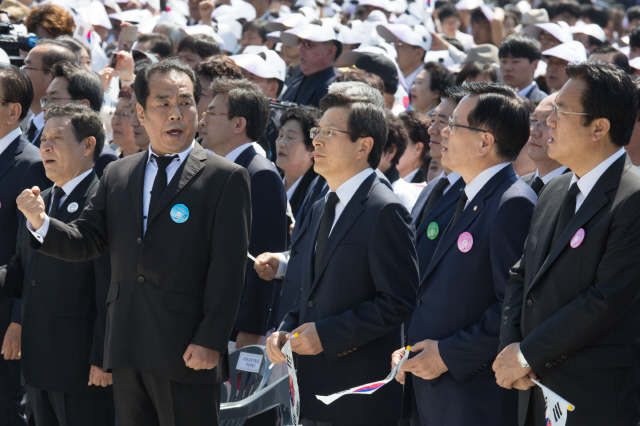 제36주년 5·18민주화운동 기념식이 열린 18일 오전 광주 북구 국립5·18민주묘지에서 ‘임을 위한 행진곡’을 참석자들이 ‘자체 제창’하고 있는 동안 한 참석자가 입을 굳게 닫고 있는 황교안 국무총리(앞줄 오른쪽 셋째)를 바라보며 노래를 따라 부르고 있다.  광주/김성광 기자 flysg2@hani.co.kr