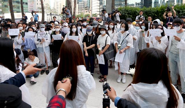 ‘강남역 여성 살인사건’으로 희생된 여성을 위한 추모 집회가 열린 지난 21일 오후, 서울 서초구 강남역 10번 출구 앞에서 흰색 우비를 입고 마스크를 쓴 참석자들이 추모행진을 준비하고 있다.  연합뉴스