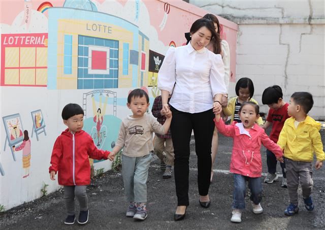 유통업계 최초 직장어린이집인 서울 종로구 재동의 롯데백화점 어린이집에서 교사가 아이들을 인솔해 걸어가고 있다.  롯데백화점 제공