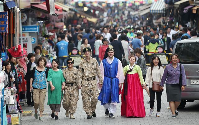 26일 오전 서울 남대문시장에서 열린 ‘남대문시장 글로벌 페스티벌’ 개막식에서 드라마 ‘태양의 후예’에 등장한 군복과 한복을 차려입은 외국인 모델들이 축제 홍보를 하며 시장 거리를 함께 걷고 있다. 연합뉴스