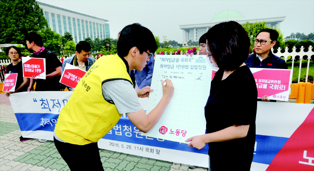 26일 오전 국회 앞에서 열린 ‘최저임금 1만원법’ 20대 국회 1호 입법 제안 기자회견에서 참가자들이 입법 청원 운동 시작을 알리고 있다. 김경호 선임기자 jijae@hani.co.kr