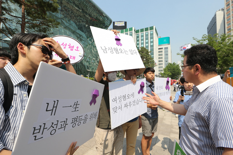 ‘양성평등연대’의 주장에 반대하는 20대 남성들이 28일 오후 서울 시청 앞에서 손팻말을 들고 맞불 시위를 벌이자 양성평등연대 회원(오른쪽)이 항의하고 있다. 김정효 기자 hyopd@hani.co.kr