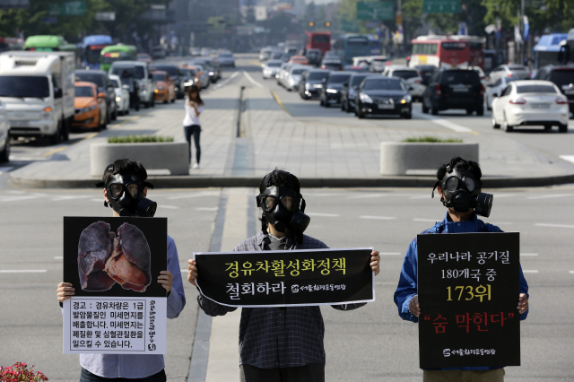 서울환경운동연합 활동가들이 지난 17일 오전 서울 종로구 세종로 광화문네거리에서 방독면을 쓰고 경유차 활성화 정책 철회 등 미세먼지 근본 대책을 정부에 촉구하고 있다. 김명진 기자 littleprince@hani.co.kr