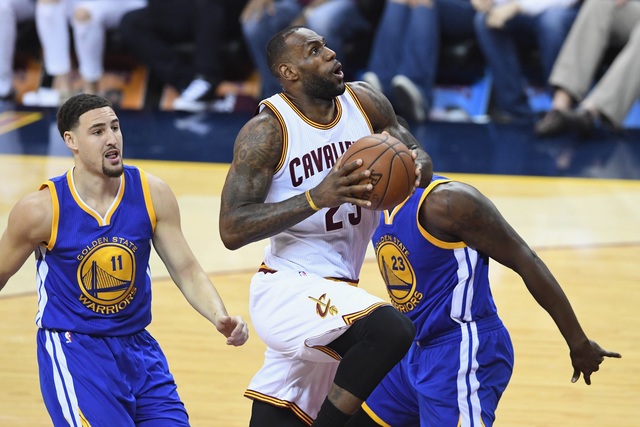  클리브랜드의 르브론 제임스(가운데)가 9일(한국시각) 열린 미국프로농구(NBA) 챔피언결정(7전4선승제) 3차전에서 골든스테이트 선수들 사이를 뚫고 림으로 솟아오르고 있다.   클리블랜드/AFP 연합뉴스